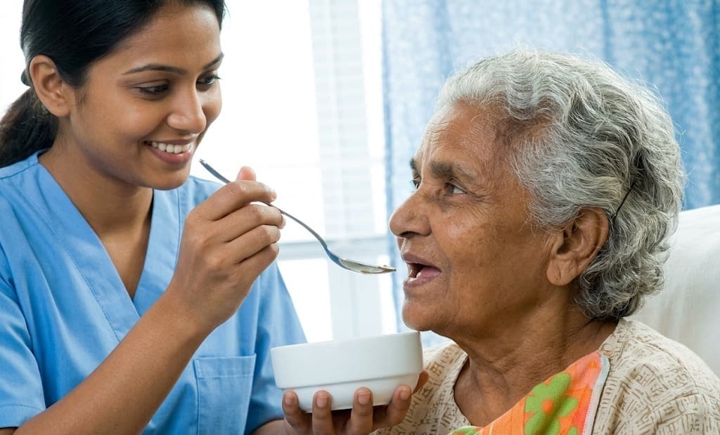 Caregiver providing compassionate daily nutrition support